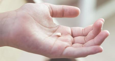 Person holding a tooth in their palm