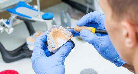 Lab technician customizing new dentures