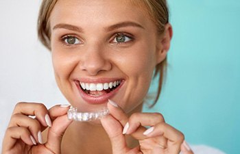 Patient in Gainesville putting their Invisalign aligners in