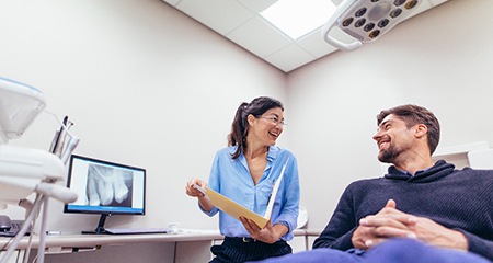 Patient and dentist smiling at each other during dental checkup