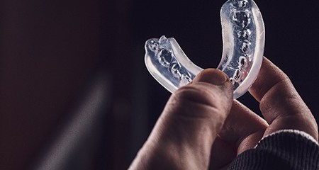 Athlete holding clear mouthguard