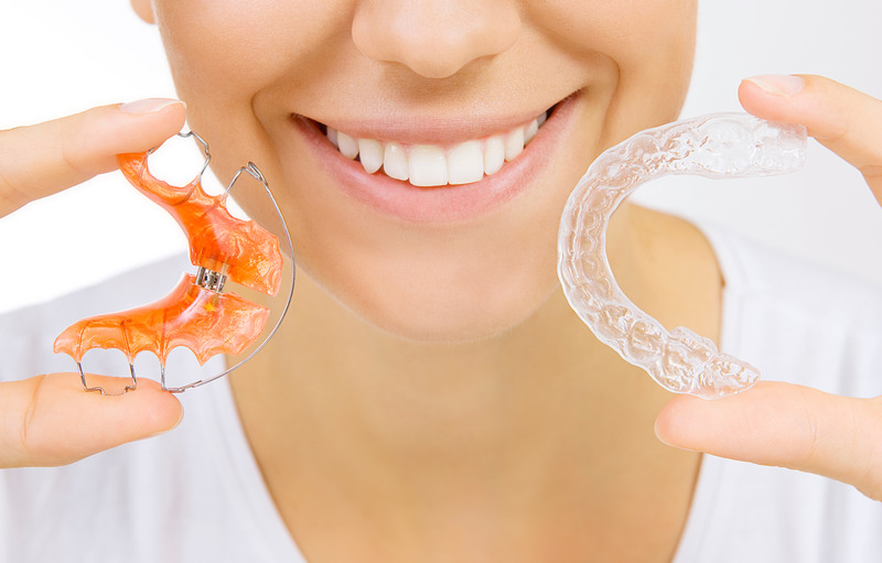 Patient holding their retainer and smiling